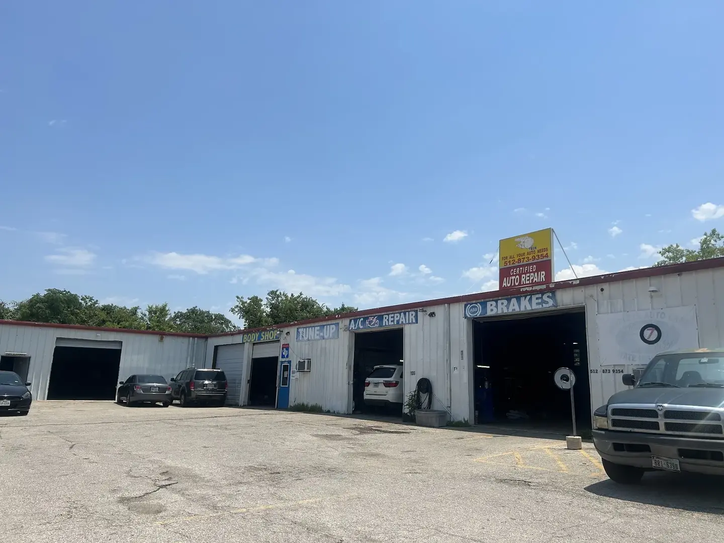 The Auto 7 Tech shop front on W Parmer Ln in Austin, with its service bays, brakes and A/C repair signs, and the Certified Auto Repair rooftop sign